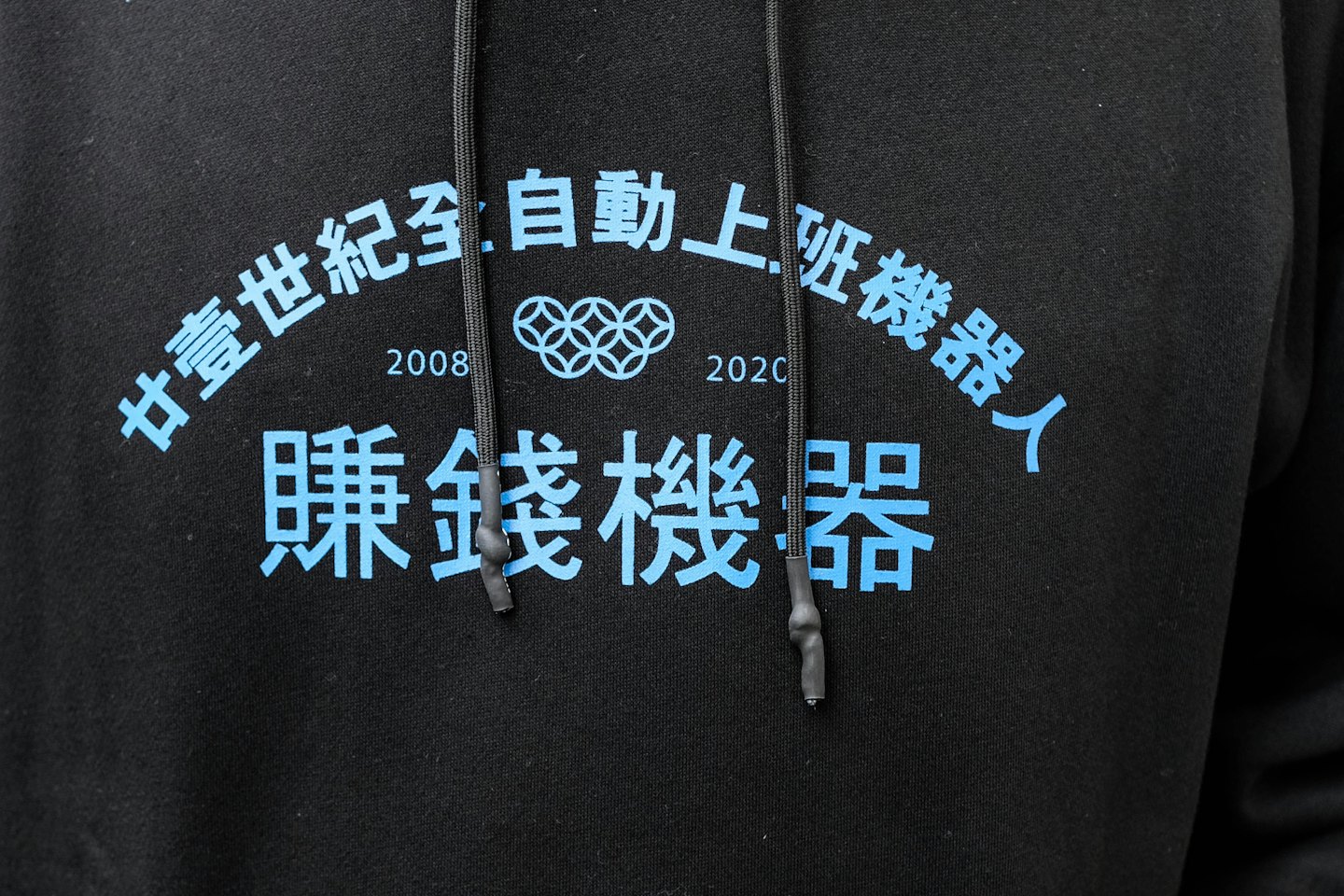Light blue decorative text printed on a black hoodie.